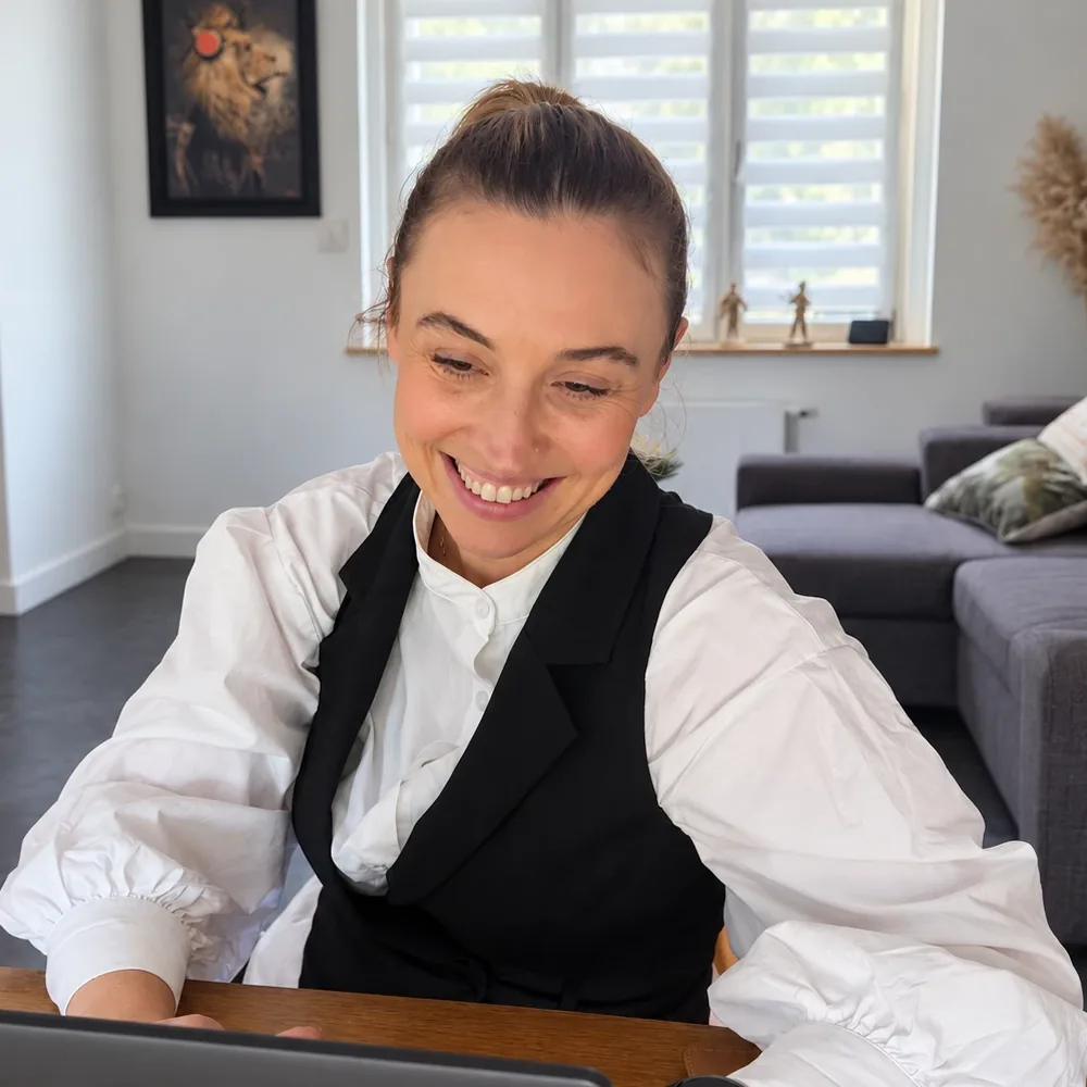 Maïté Kindts, dirigeante fondatrice d'Ergogène, souriante devant son ordinateur