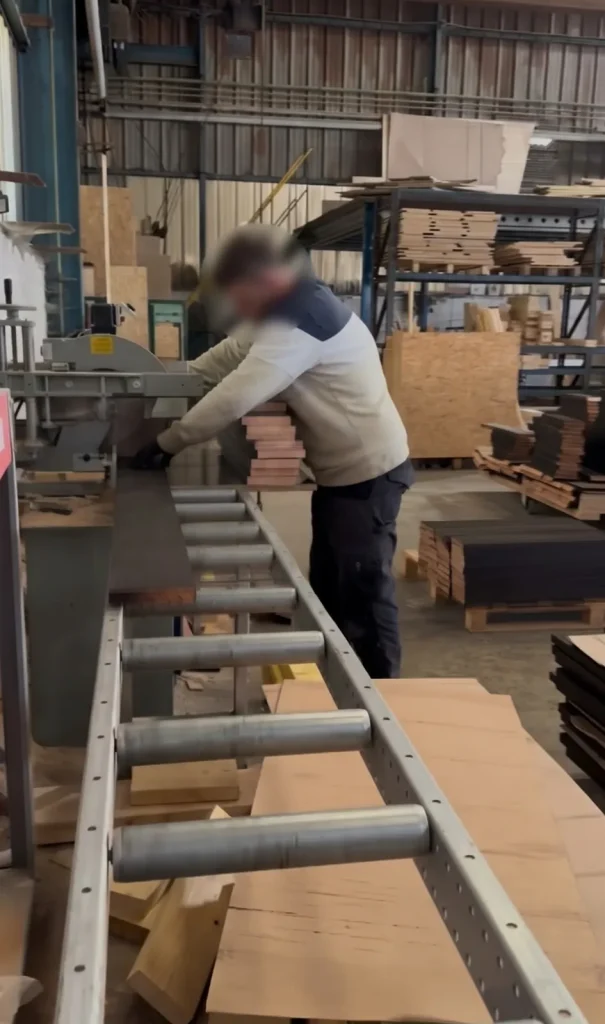 Opérateur sur une scie à format dans un atelier de menuiserie